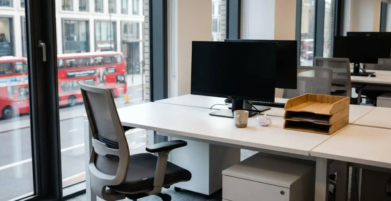 Empty office desk with cleared personal items in a contemporary UK workplace